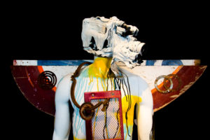 sculpture of man with paint on body and wings on back