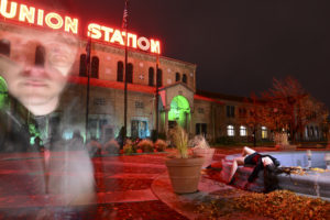 behind the mask, Chris Moss, image of girl laying on the ground with man in the other side of the picture and old building in the background