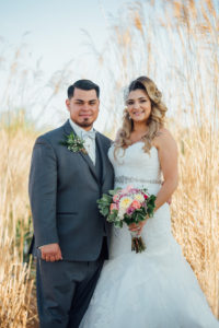 MOSS IMAGE, bride and groom with bride holding flowers with tall grass in background