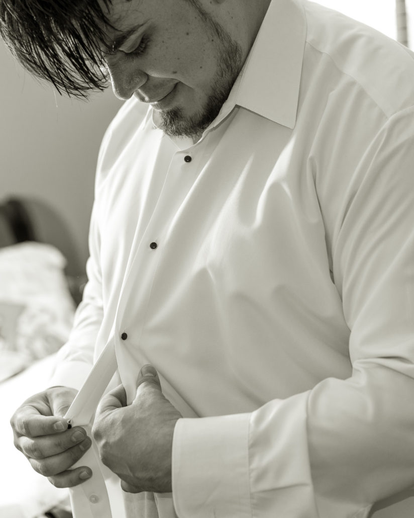 Wedding, Moss Image, Moab Photographer, Portrait, Chris Moss, black and white photo of man buttoning up his shirt while looking down