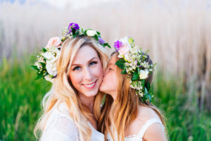 Portrait, CHris Moss, Moss Image, girl kissing her mom on the cheek with flowers in their hair and green grass in the background