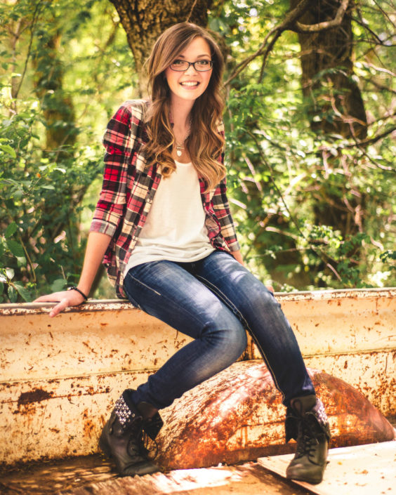 Moab, Portrait, Photo, chris moss, Girl sitting in the bed of an old truck wearing blue jeans and a red plaid shirt with trees in the background