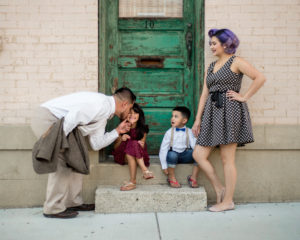 picture of a family sitting in front of a green door