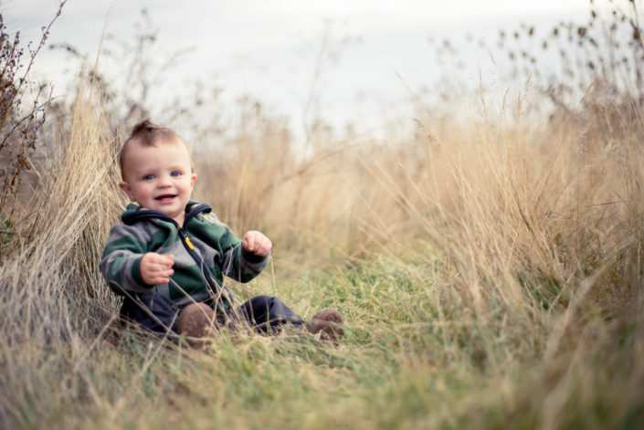 Portrait, Chris Moss, Moab Photographer, picture of a boy sitting in the grass and smiling while looking at the camera