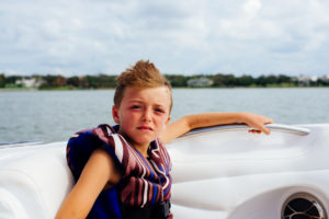 boy on boat in life jacket, moss image, cuba, florida, chris moss
